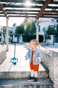 Full length of boy standing on railing