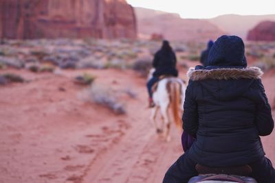 Rear view of people on horses in desert
