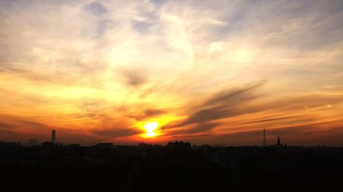 Silhouette city against sky during sunset