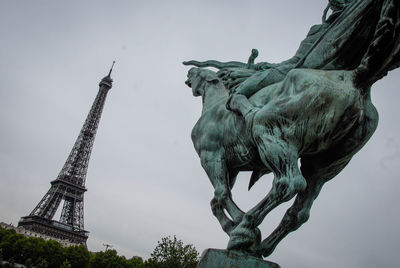 Low angle view of statue attacking the eiffel tower