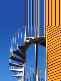 Low angle view of staircase against clear blue sky