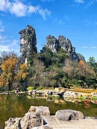 Rocks by lake against sky