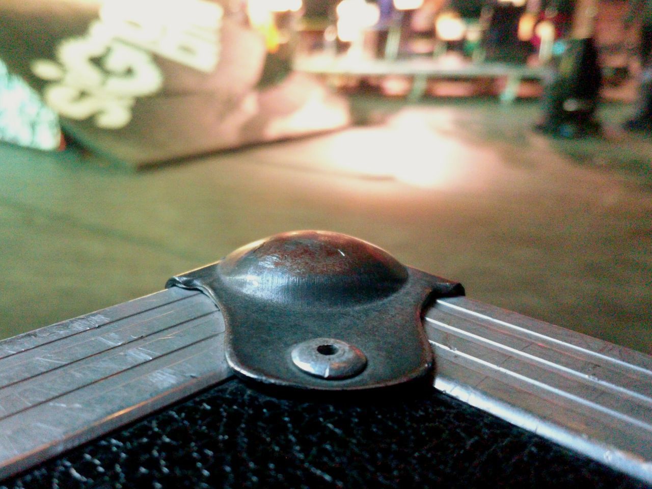 CLOSE-UP OF METAL ON STREET AGAINST BLURRED BACKGROUND