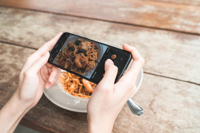 Cropped hands of woman using mobile phone