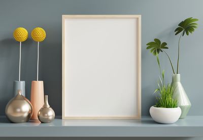 Poster mockup with wooden frame in home interior on blue wall background.3d rendering
