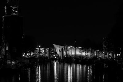 Illuminated building by water at night