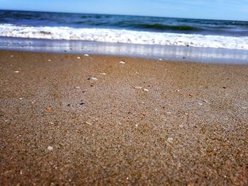 Close-up of sand on beach against sky