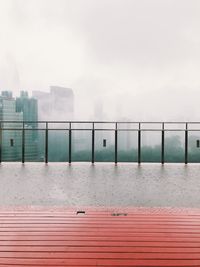 View of swimming pool by railing against cityscape