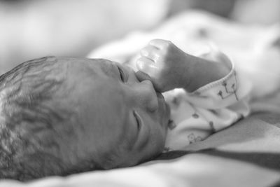Close-up of baby lying on bed