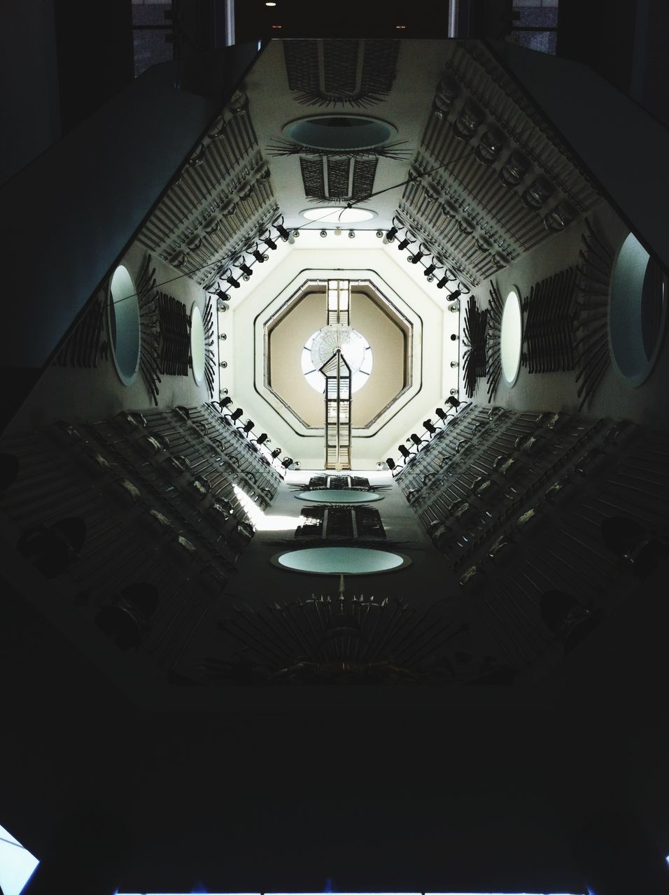 indoors, low angle view, architecture, ceiling, built structure, illuminated, lighting equipment, directly below, architectural feature, pattern, building, no people, church, design, window, ornate, chandelier, place of worship, electric light, interior