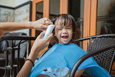 Cheerful girl doing haircut at salon
