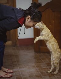 Woman with dog standing on tiled floor