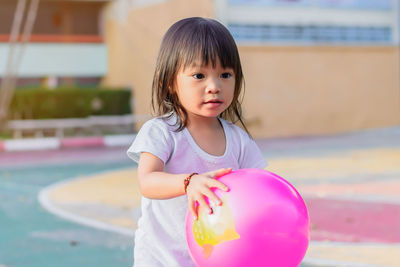 Cute girl playing with ball at park