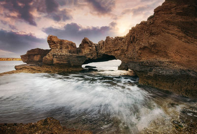 Rocks on sea shore against sky