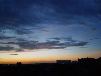 Silhouette cityscape against sky during sunset