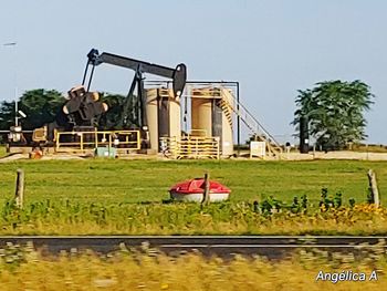 Built structure on field by lake against clear sky