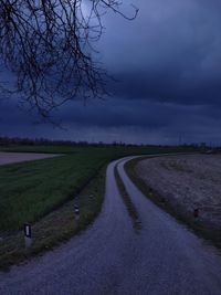 Road amidst field against sky