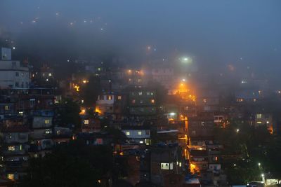 Illuminated cityscape against sky at night