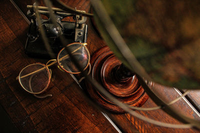 Close-up of eyeglasses with hole punch and globe on table