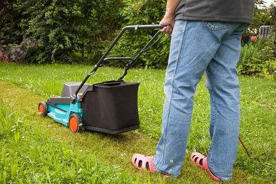 Low section of man mowing lawn