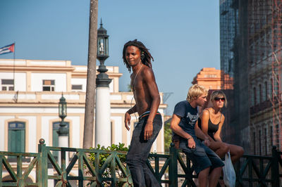 Woman standing by railing against buildings in city