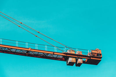 Low angle view of crane against blue sky