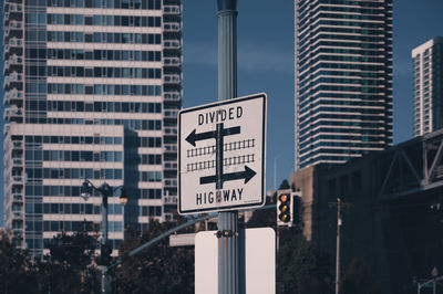 Road sign by buildings in city