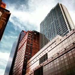 Low angle view of modern building against cloudy sky