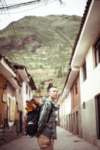 Portrait of funky female traveler with back pack and colourful fabric