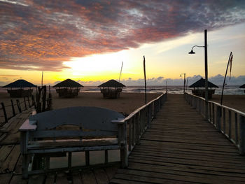 Pier over sea against sky during sunset