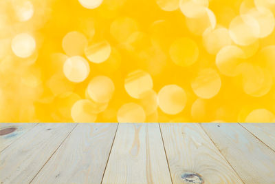 Close-up of yellow lights on wooden table
