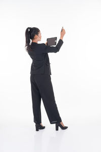 Full length of woman standing against white background