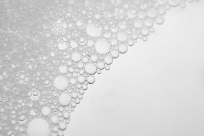 Close-up of wet bubbles against white background