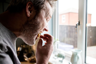 Close-up of man eating at home