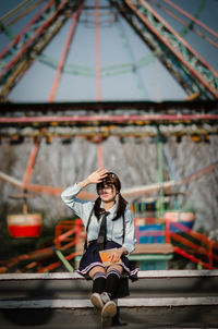 Portrait of young woman sitting on bridge