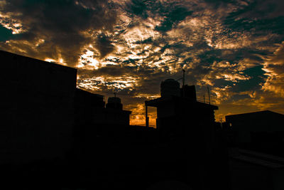 Low angle view of silhouette buildings against sky during sunset