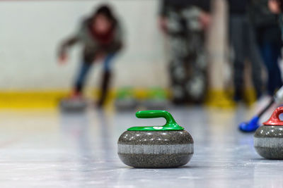 Low section of people playing curling on ice rink