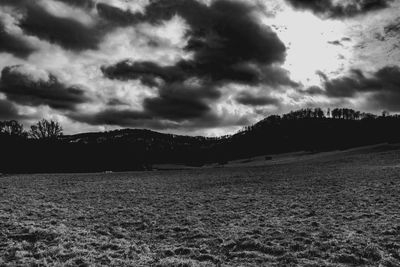 Scenic view of field against dramatic sky