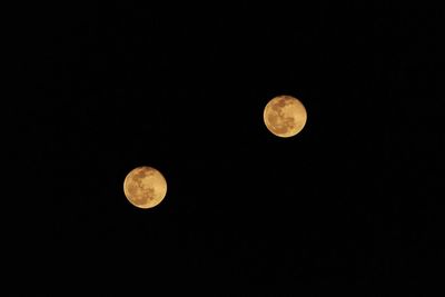 Low angle view of full moon against clear sky at night