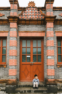 Cute boy sitting by door