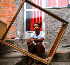 Portrait of smiling man sitting against building