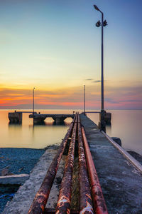 Pier over sea against sky during sunset