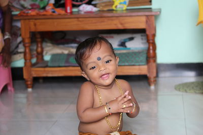 Portrait of cute baby boy on floor at home