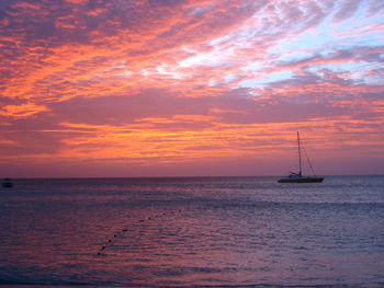 Sailboat sailing on sea against sky during sunset