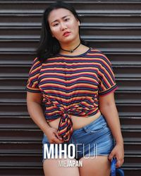 Portrait of beautiful young woman standing against wall