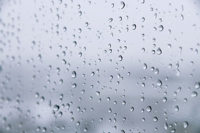 Raindrops on glass in cold colors. soft focus cold background rainy day