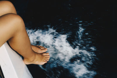 Low section of woman splashing water