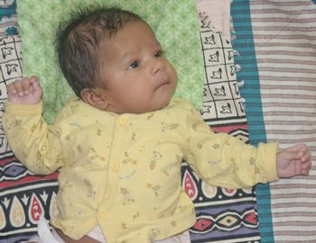 Cute baby girl lying on bed