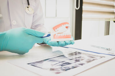 Close-up of dentist working at desk in medical clinic