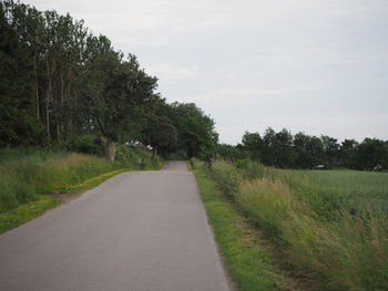 Empty road passing through field